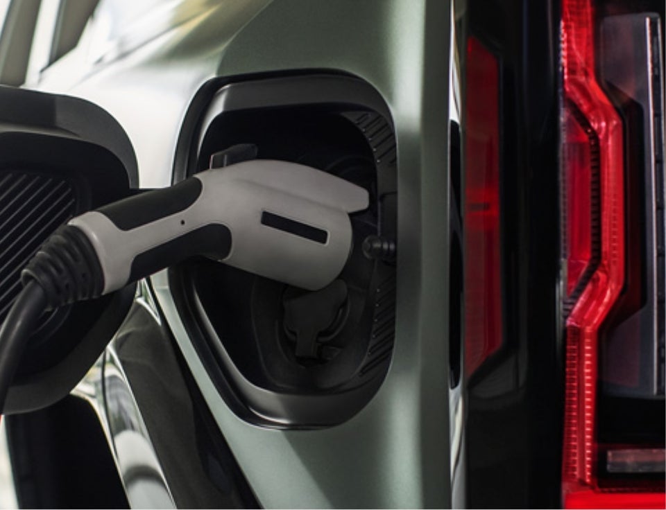 Close up of charging port with charger plugged in on a GMC Hummer EV SUV - Harry Brown's GMC in Faribault MN